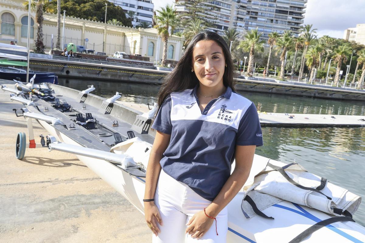 Lucía Navarro, junto a una embarcación de equipo en el Real Club de Regatas de Alicante