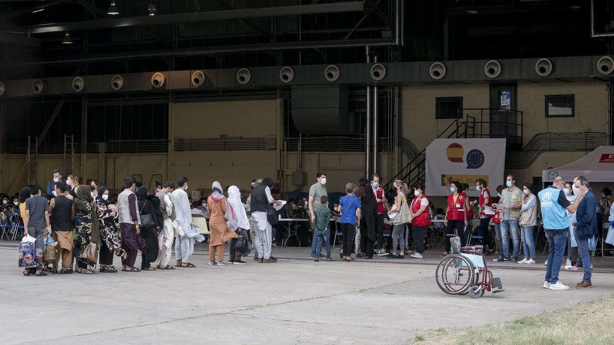 Varios refugiados tras la llegada de un nuevo avión con 260 personas procedentes de Afganistán, en la base aérea de Torrejón de Ardoz, a 23 de agosto de 2021, en Madrid (España). Un total de siete aviones han salido desde el aeropuerto de Kabul hacia la b