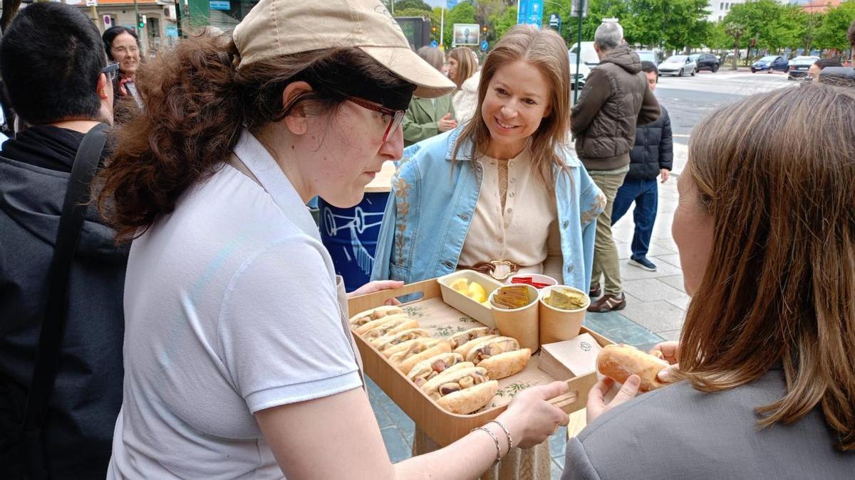 Una empleada reparte bocadillos en el Quiosco Down Experience en la plaza de Ourense.