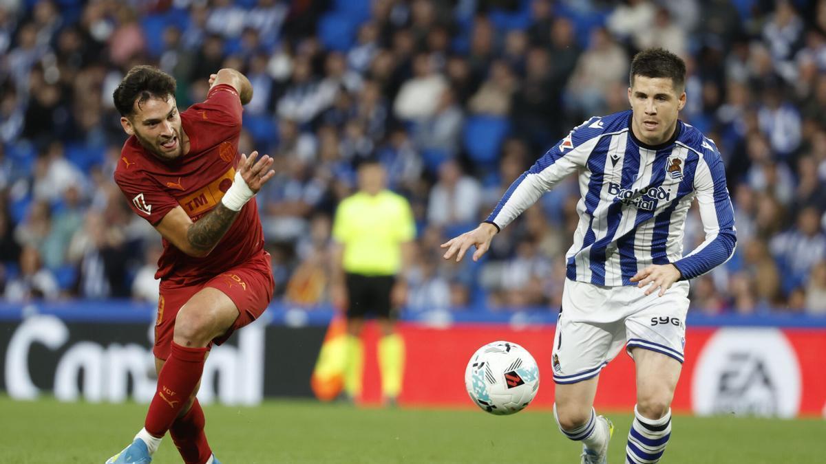El defensa de la Real Igor Zubeldia juega un balón ante Hugo Duro