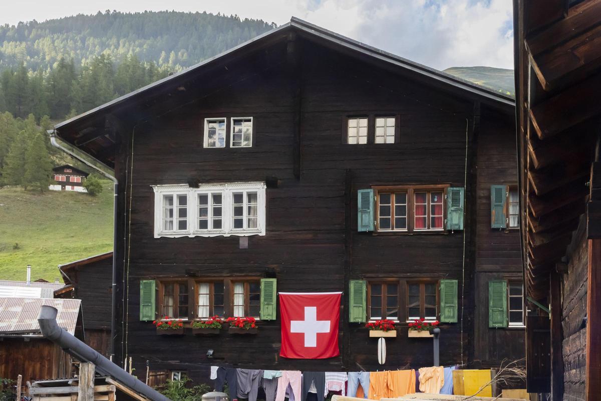 Archivo - Una bandera suiza en una construcción tradicional en los Alpes.