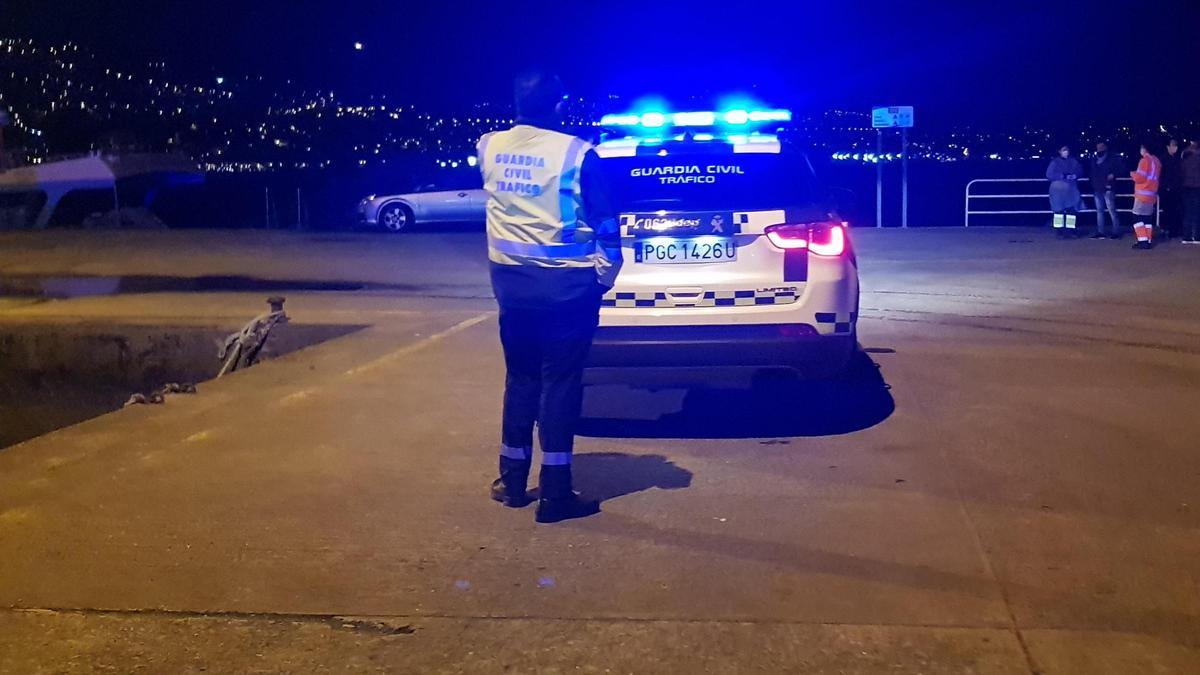 Un agente de la Guardia Civil, esta madrugada, con el coche rescatado al fondo. / F.G.S.