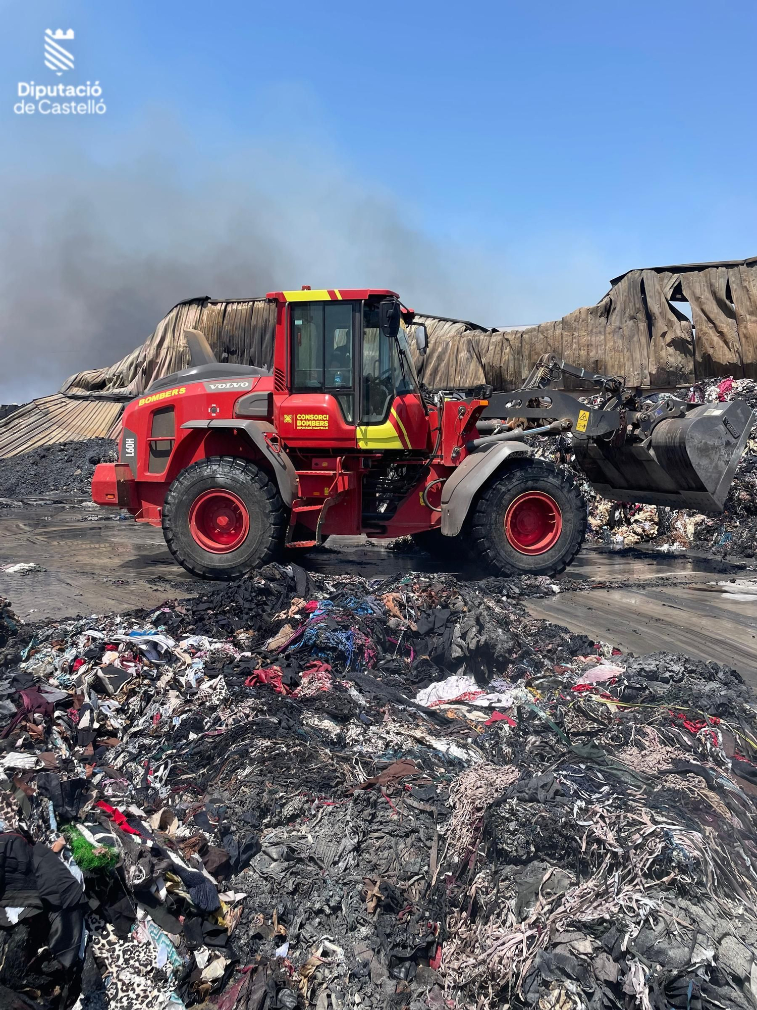 Los bomberos siguen trabajando en el en el incendio industrial de la nave de textil de Almassora