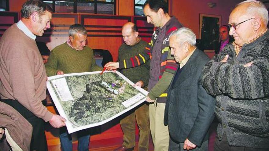 Participantes en la reunión de ayer observan el mapa de la zona que muestra Adolfo Fueyo.