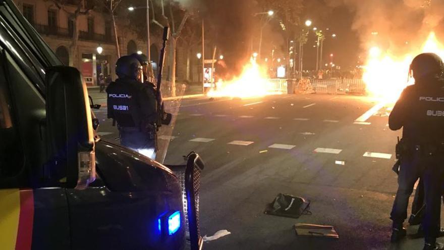 Agents de la Policia Nacional davant d&#039;una barricada cremant