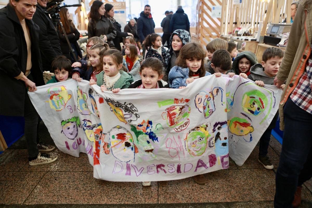 Los niños y niñas de la escuela de Donramiro, con una pancarta en la feria Merca Delicadeza.