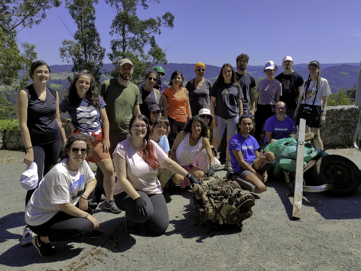 Los voluntarios posan con restos del coche retirado de A Espenuca.