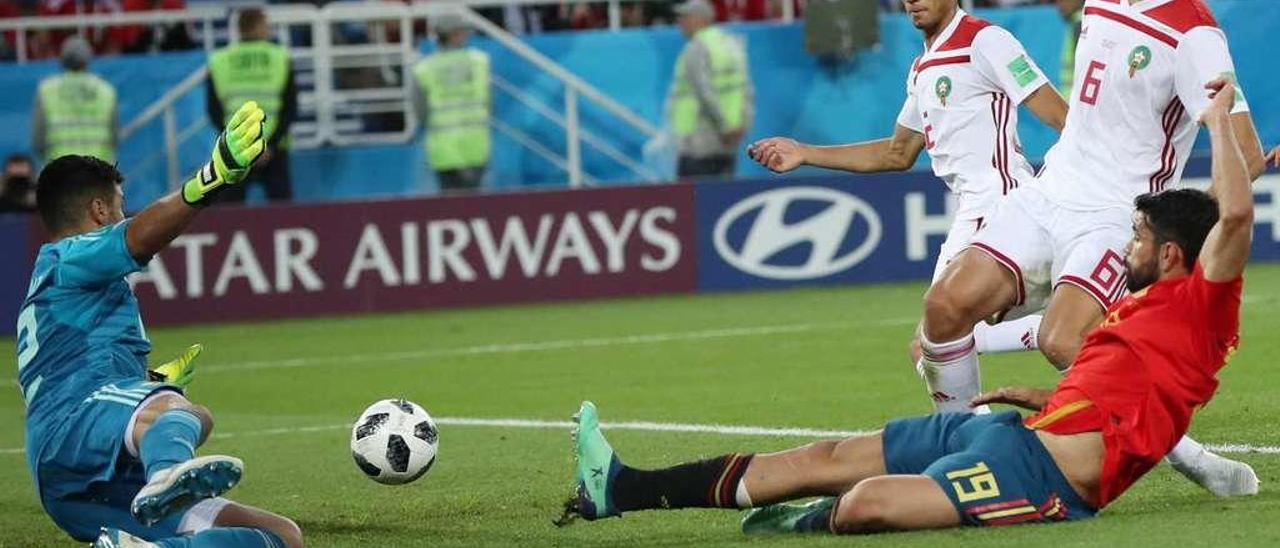 Diego Costa no alcanza el balón de Iniesta para superar a Munir, portero de Marruecos, con Saiss y Achraf Hakimi siguiendo la jugada. // Martin Divisek