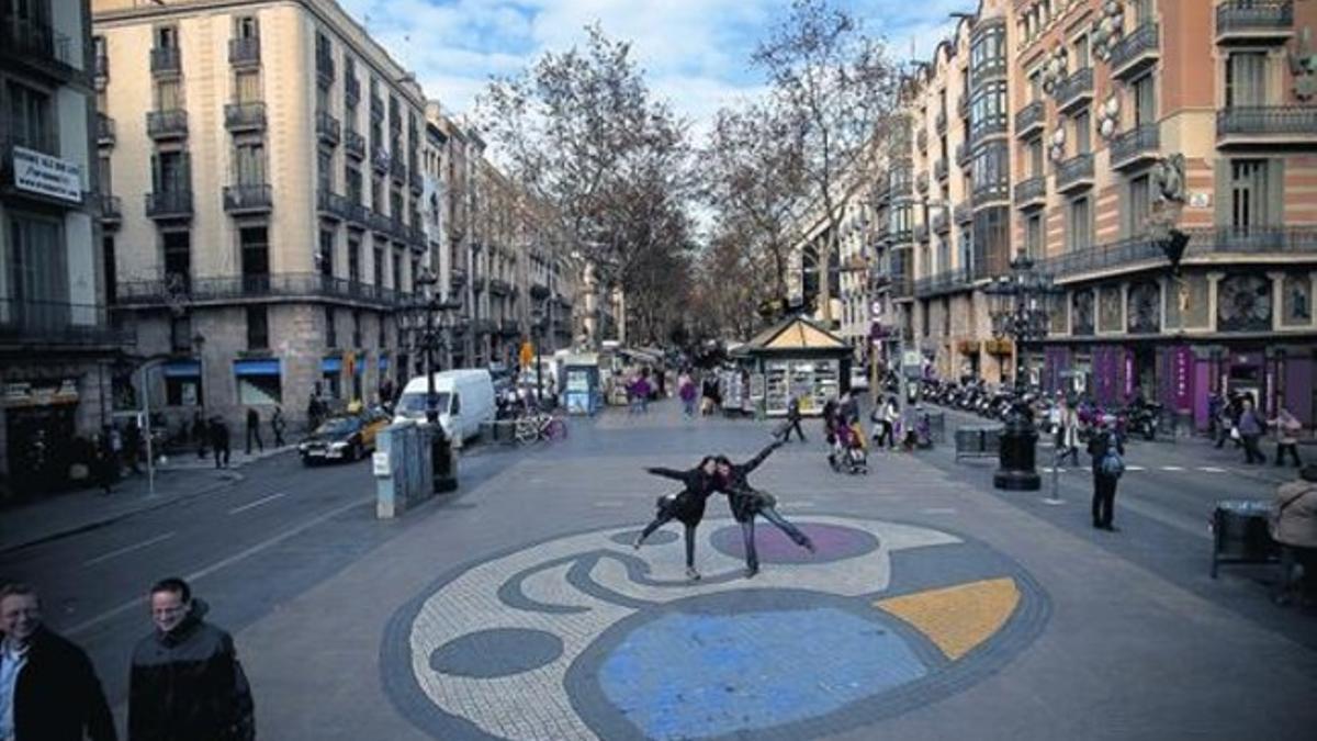 Dos jóvenes se fotografían, ayer, sobre el mosaico de Joan Miró de la Rambla, próximo al Gran Teatre del Liceu.