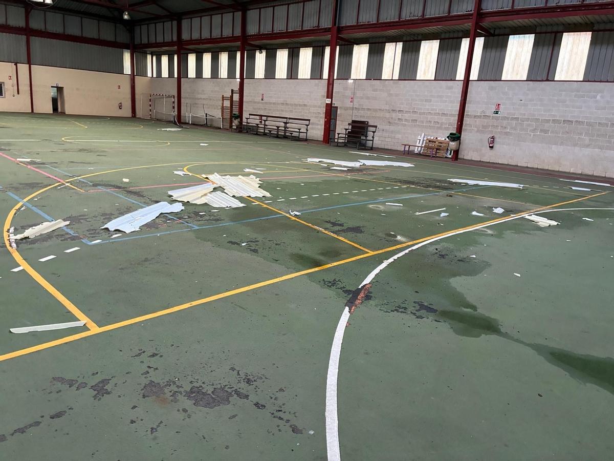 Cascotes y restos de la cubierta en la pista del polideportivo de La Atalaya.