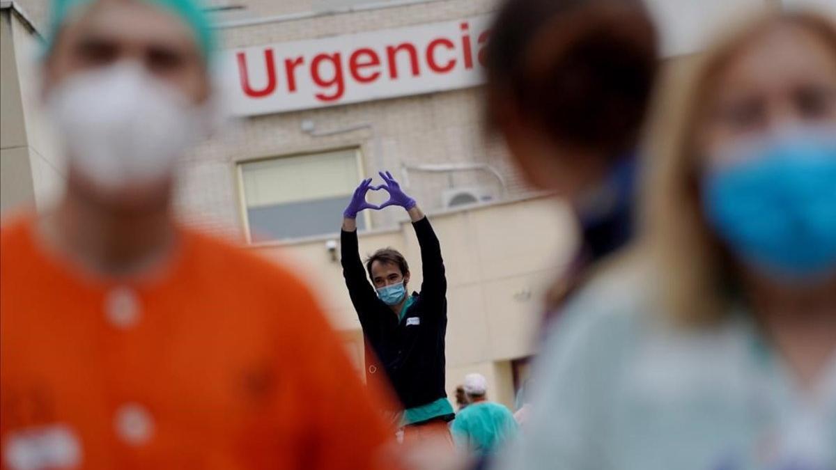 Varios sanitarios, durante los aplausos de homenaje de las ocho de la noche, en el Hospital Gregorio Marañón de Madrid, el 2 de abril