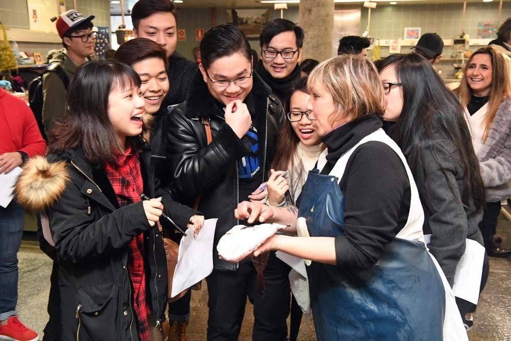 Una treintena de alumnos del Centro de Linguas de la Universidad coruñesa procedentes de China y Vietnam visitan el mercado de la plaza de Lugo para aprender argot gastrónomico gallego.