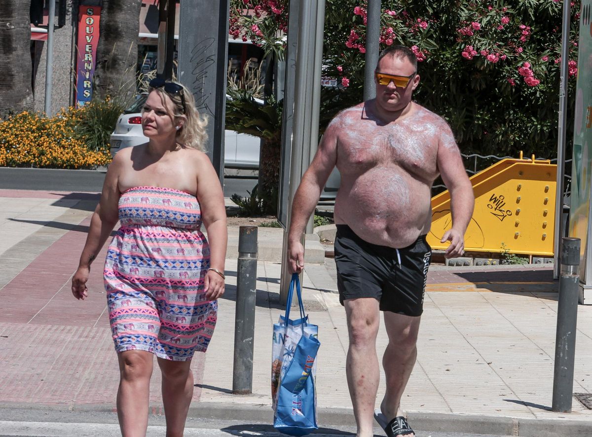 Dos turistas camino de la playa en Alicante.