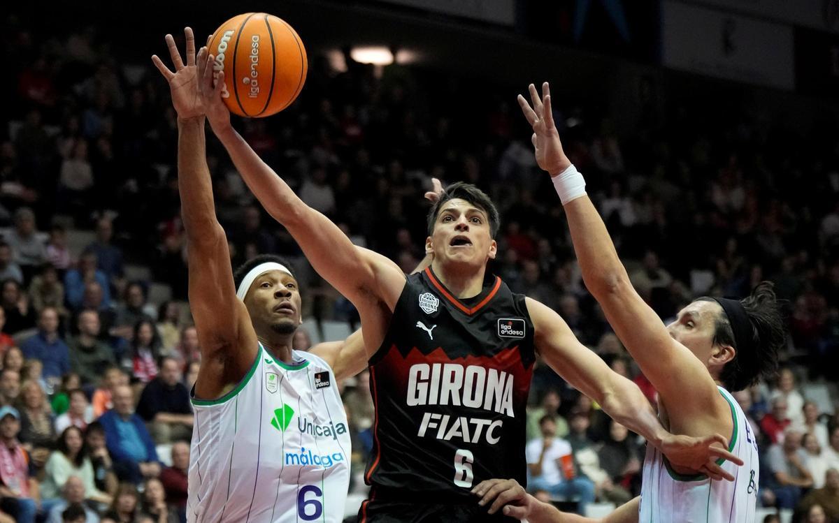 Juani Marcos trata de anotar en presencia de Taylor y Djedovic