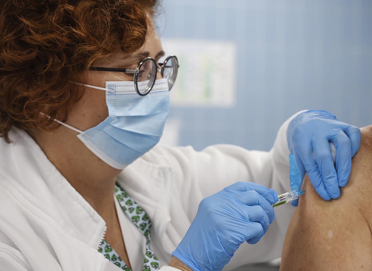 Una enfermera vacuna en la campaña de vacunación frente a la gripe y la Covid-19