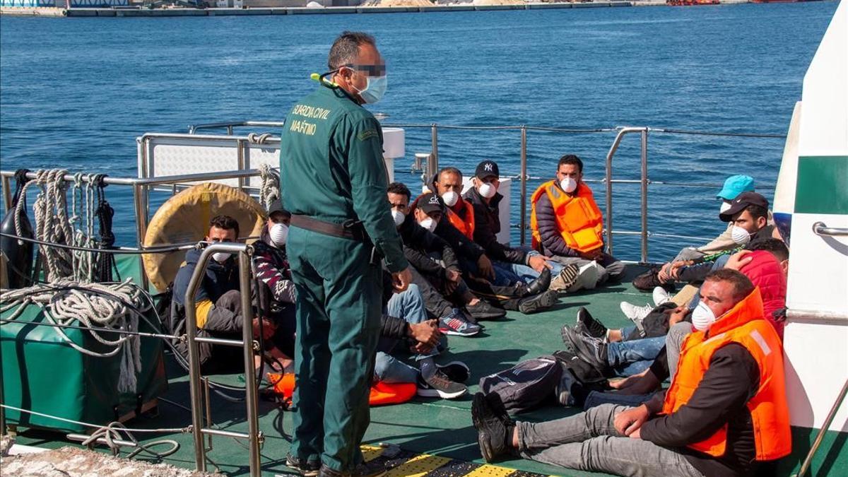 Agentes de la Guardia Civil trasladan al puerto de Motril (Granada) a un grupo de inmigrantes magrebís interceptados en una lancha neumática frente a la costa granadina.