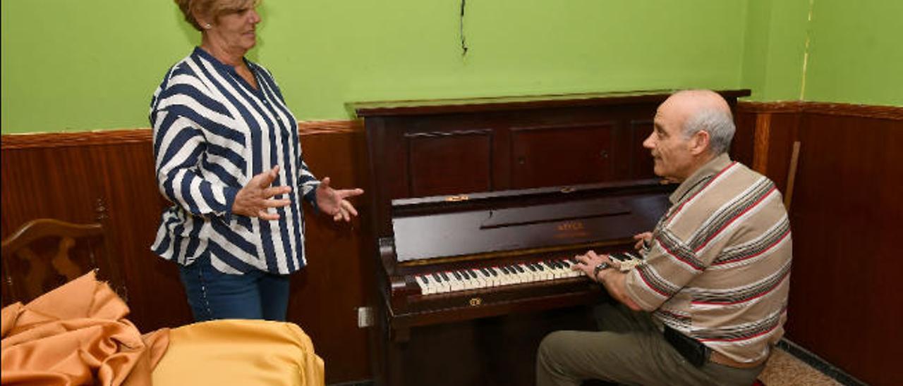 Dos miembros de la Junta saliente de la Sociedad de Cultura y Recreo La Juventud de Ingenio junto a un piano, ya donado a la parroquia del Santo Cristo.