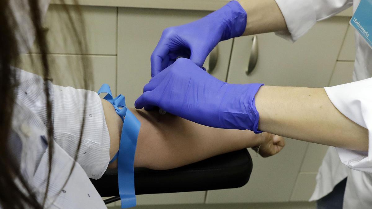 Un trabajador sanitario prepara a una paciente para la extracción de sangre para realizar el test serológico IgM/IgG SARS-CoV-2