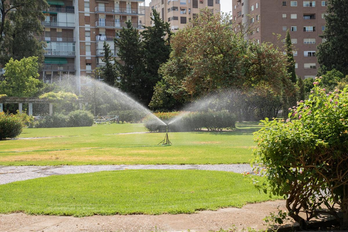 Aspersores de riego en una zona verde del Parque de los Príncipes de Sevilla para el mantenimiento de jardines y áreas ajardinadas
