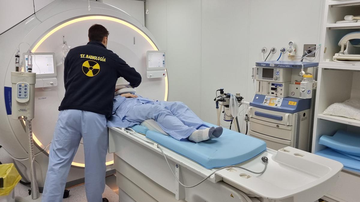 Un técnico de radiología ayuda a un paciente a entrar en la máquina de resonancia de un hospital de la provincia