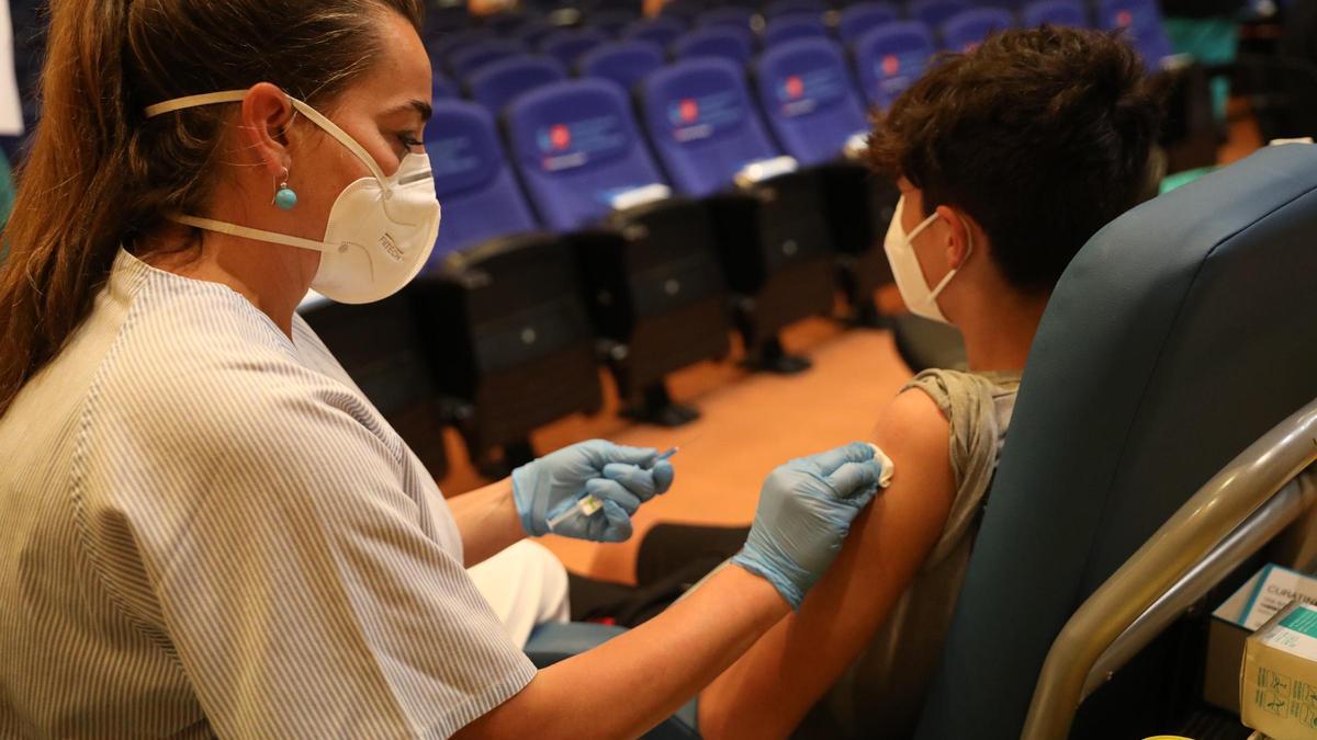 Una sanitaria administra una vacuna contra el coronavirus a un menor.