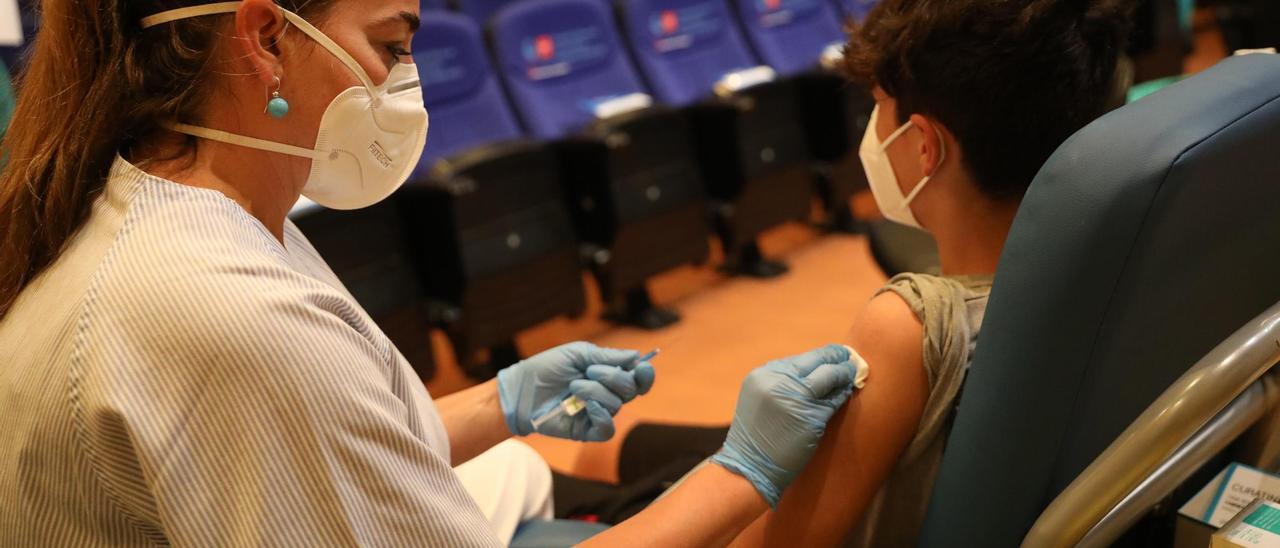 Una sanitaria administra una vacuna contra el coronavirus a un menor.
