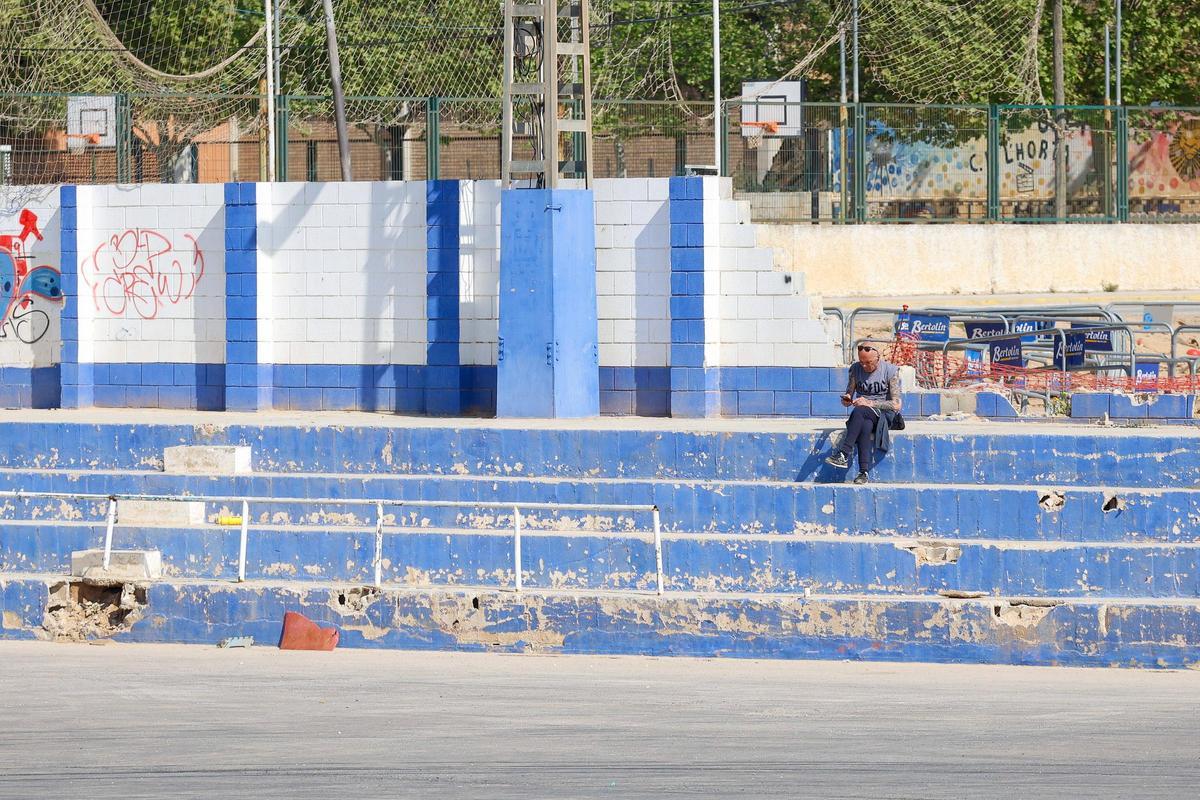 Un hombre utiliza el móvil en la grada del estadio El Palleter de Paiporta, el miércoles pasado.