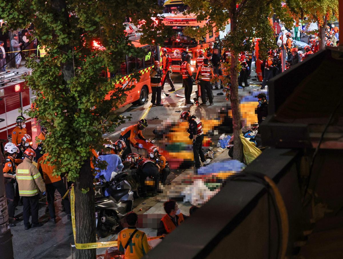 Rescue team and firefighters work on the scene where dozens of people were injured in a stampede during Halloween festival in Seoul