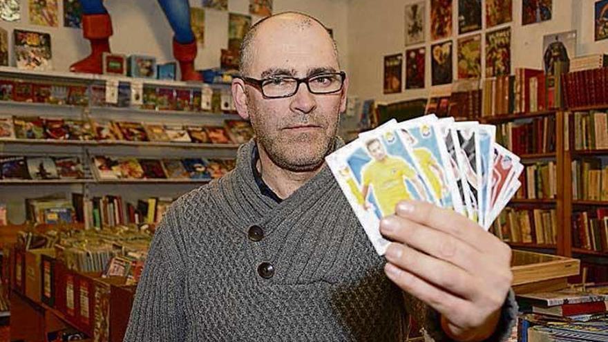 Fernando López posa con los cromos en su tienda.