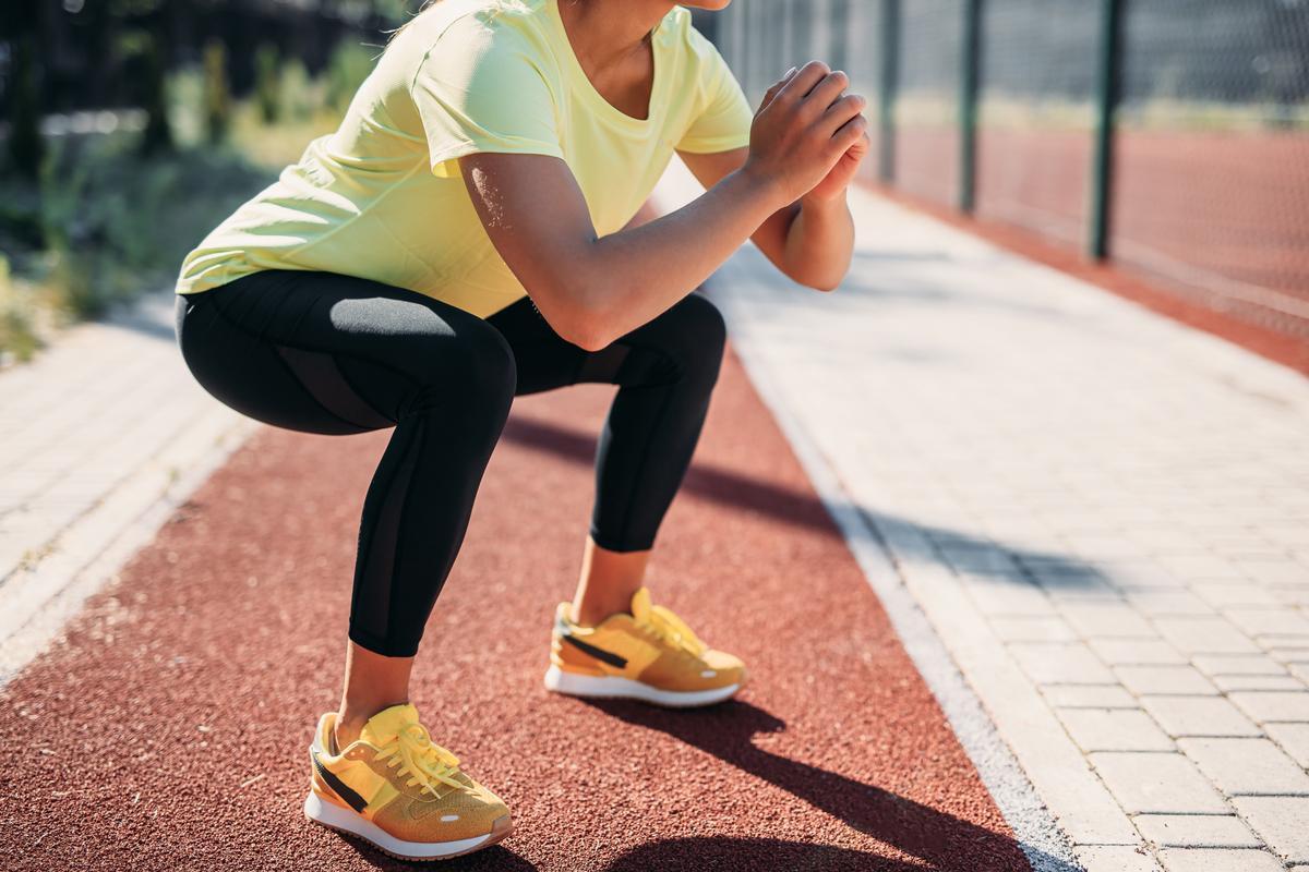 Una runner haciendo sentadillas durante su entrenamiento