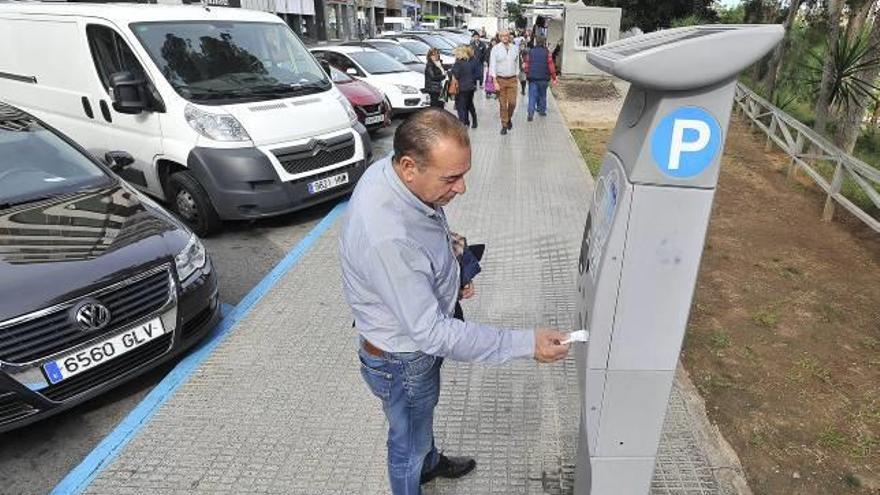 Un conductor saca en una calle del centro el correspondiente billete para colocarlo en el salpicadero del vehículo.