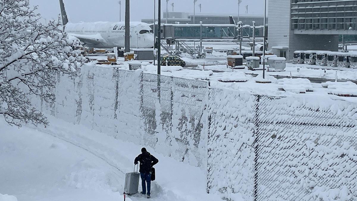 Una persona con su maleta en el aeropuerto de Múnich totalmente nevado, este sábado.
