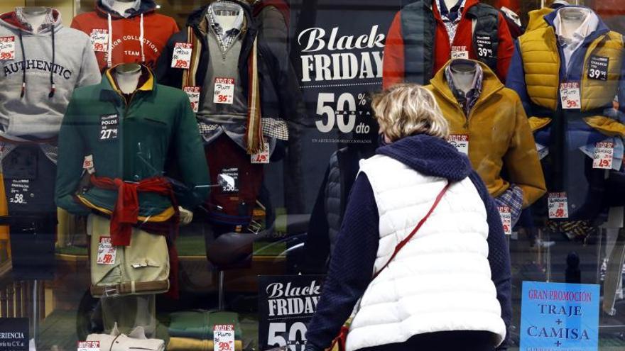 Una mujer mira el escaparate de una tienda de Zaragoza, ayer, con numerosos descuentos con motivo del Black Friday. | JAIME GALINDO