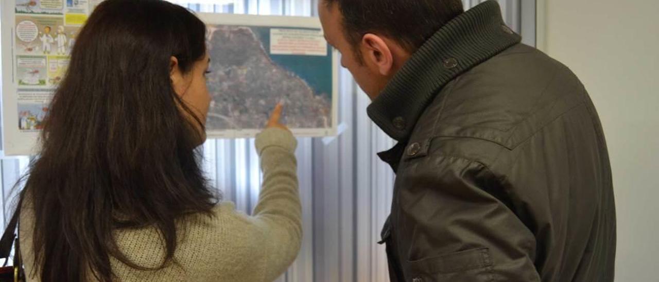 Dos vecinos estudian el mapa que refleja el área de la concentración parcelaria.