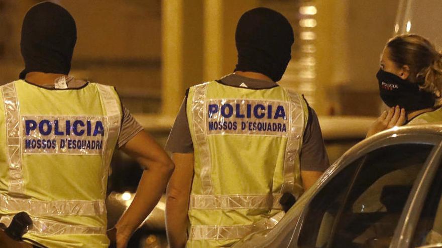 Agentes de los Mossos durante el registro a una vivienda.