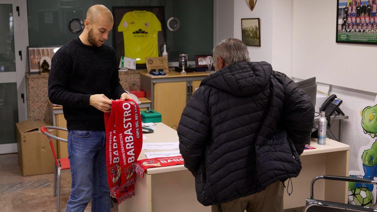 Un aficionado compra bufandas en la sede del club