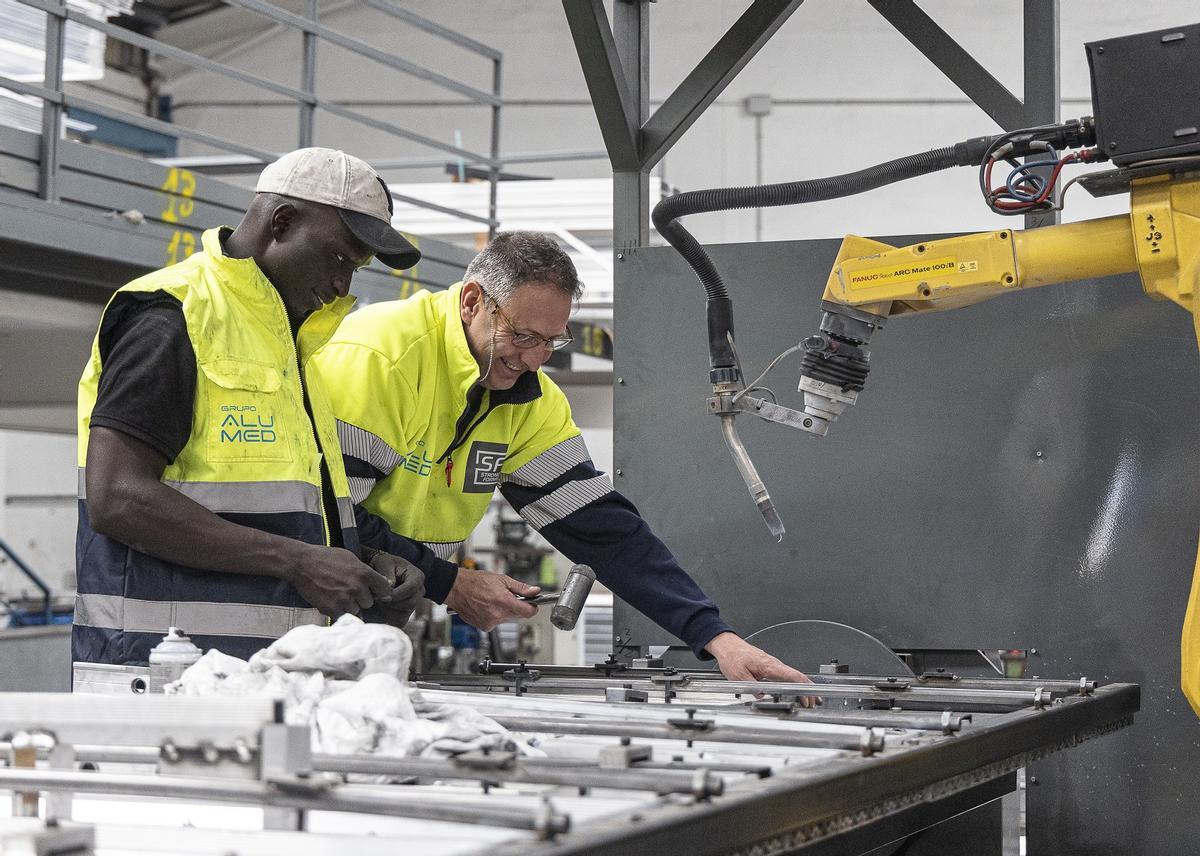 Dos operarios de la empresa del grupo Alumed.