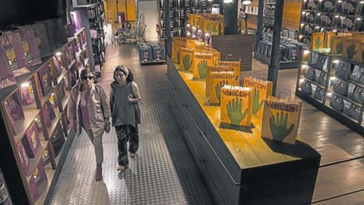 Vinçon, en su acceso por la calle de Provença, y con la colección de bolsas de la tienda a la venta.