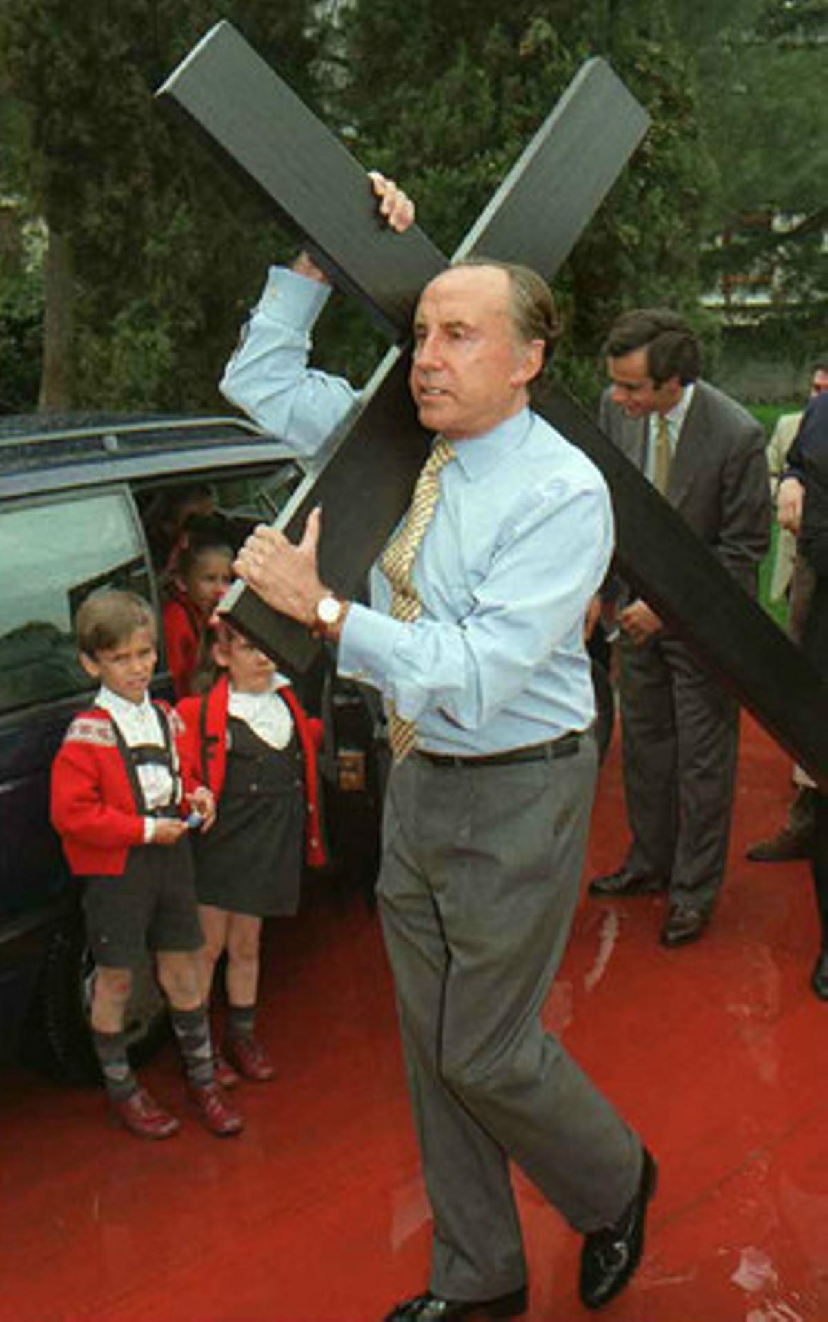 El empresario José María Ruiz-Mateos esperando a los agentes de Policia con una cruz de penitentes a hombros minutos antes de su detención en 1996.