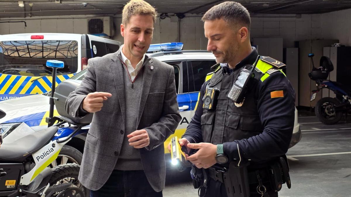 A l'esquerra, l'alcalde de Figueres, Jordi Masquef, amb un agent amb una pistola Taser