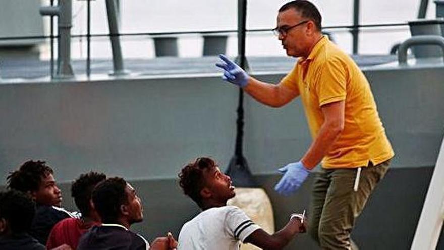 Un policia parla amb un grup d&#039;immigrants rescatats al Mediterrani
