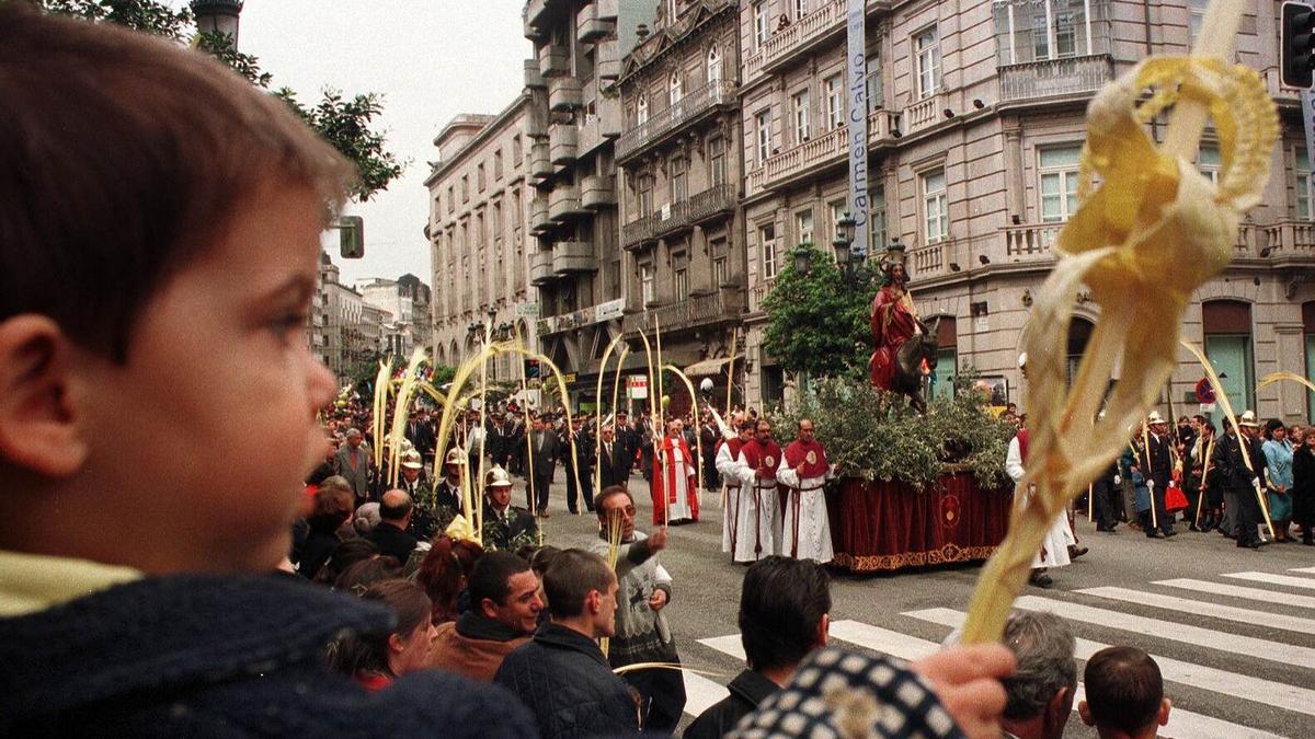 1999   Un niño con un ramo mira el paso de la procesión de la Borriquita