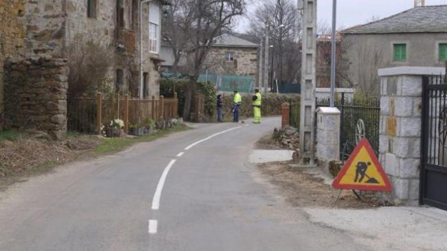 Una vecina conversa con unos obreros en la travesía de Paramio.