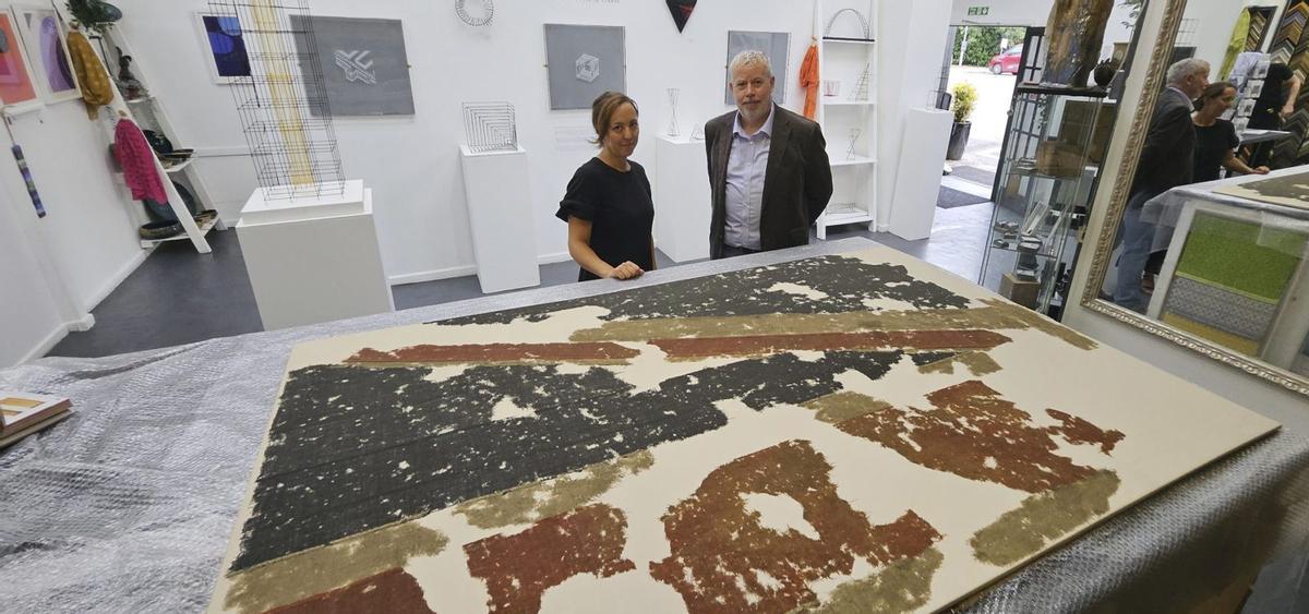 Sarah Morris, conservadora, y el catedrático Howard Fuller con parte de la bandera restaurada del «HMS Captain».