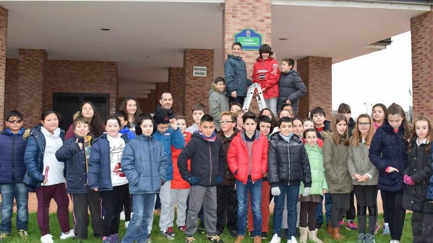 Los alumnos y exalumnos del colegio público El Carbayu posan junto a la nueva placa de la calle.