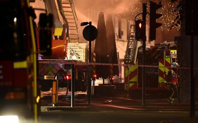 A firefighter walks near a fire at Camden Market ...