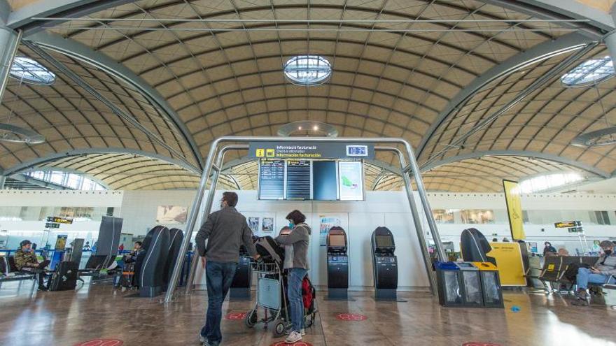 Pasajeros frente a uno de los paneles donde se anuncian salidas de vuelos.