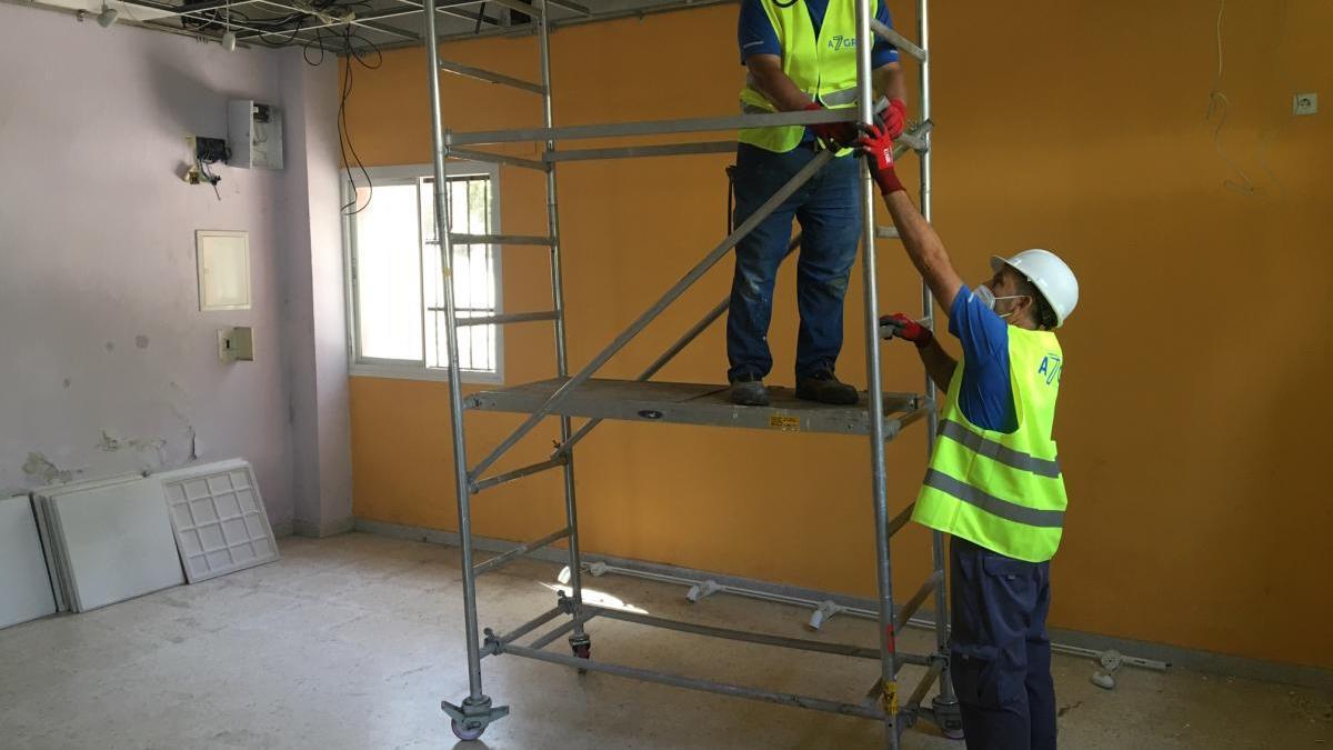 Dos operarios realizan obras de mejora en el interior del Centro Cívico de Las Albarizas.