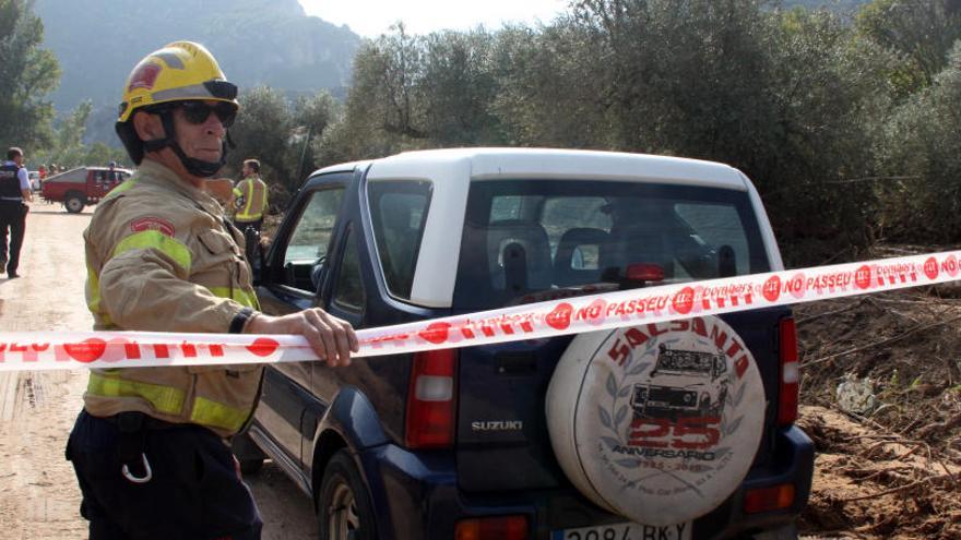 Un bomber deixant passar un vehicle amb el metge forense