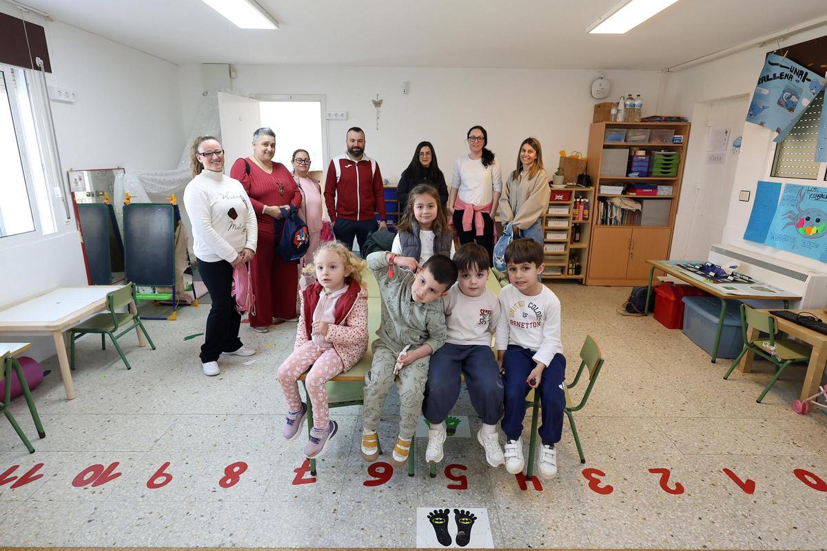 Interior de la escuela unitaria de Curro, con familias, alumnos y su maestra.